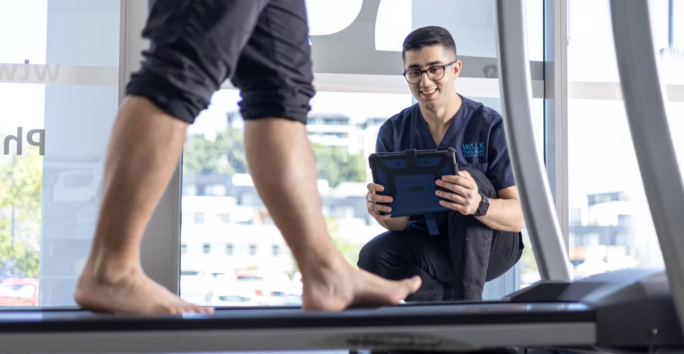 Podiatrist performing gait analysis for orthotics prescription